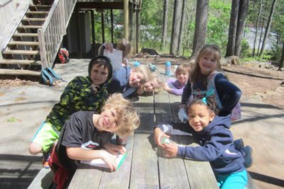 kids sitting at picnic table making crafts